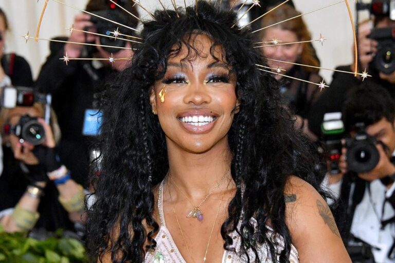 SZA sorrindo no tapete vermelho do Met Gala.